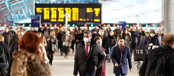 رجل يرتدي قناعا للوجه في محطة واترلو في لندن - سبوتنيك عربي