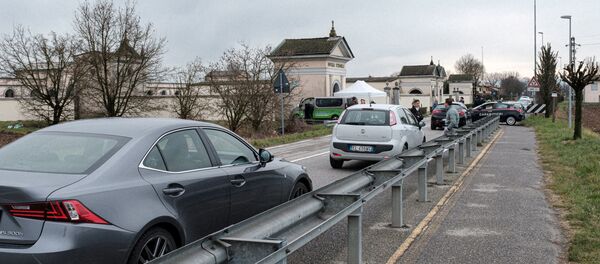 الحياة داخل المنطقة الحمراء: ينتظر طابور من السيارات على الحدود بين مدينتي سان فيورانو وسانتو ستيفانو المعزولتين في شمال إيطاليا  - سبوتنيك عربي