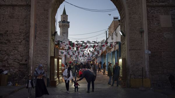 الناس بالقرب من أحد مداخل المدينة القديمة في طرابلس في ليبيا - سبوتنيك عربي