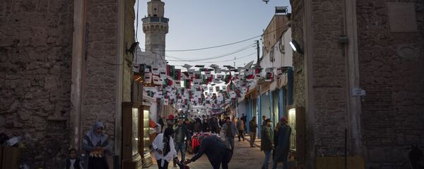 الناس بالقرب من أحد مداخل المدينة القديمة في طرابلس في ليبيا - سبوتنيك عربي
