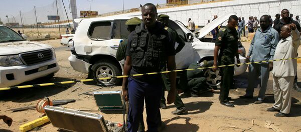 أفراد الأمن يقفون بالقرب من سيارة تضررت إثر انفجار استهدف موكب رئيس الوزراء السوداني عبد الله حمدوك بالقرب من جسر كوبر بالخرطوم - سبوتنيك عربي