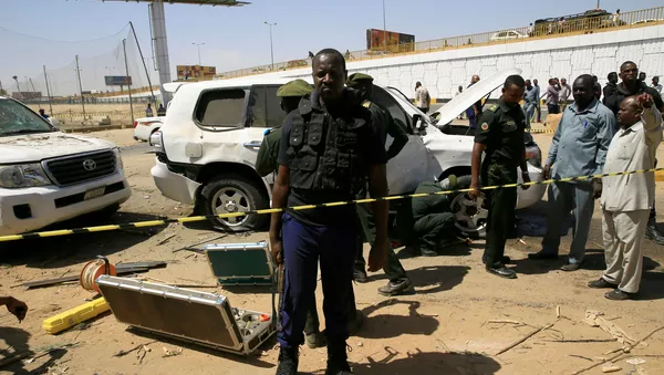 أفراد الأمن يقفون بالقرب من سيارة تضررت إثر انفجار استهدف موكب رئيس الوزراء السوداني عبد الله حمدوك بالقرب من جسر كوبر بالخرطوم - سبوتنيك عربي