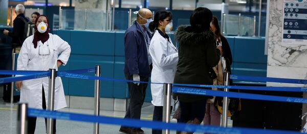 فريق طبي تونسي يوزع أوراق المعلومات عند وصول الركاب إلى مطار تونس بعد فحصهم بواسطة الماسحات الضوئية الحرارية لمعرفة أعراض فيروس كورونا - سبوتنيك عربي