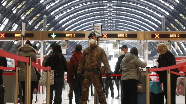 ضباط الشرطة والجنود يفحصون المسافرين الذين يغادرون محطة القطار الرئيسية في ميلانو في إيطاليا في محاولة لتأمين 16 مليون شخص -أكثر من ربع سكانها– من فيروس كورونا - سبوتنيك عربي