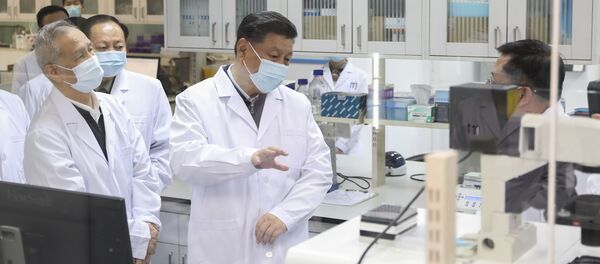 الرئيس الصيني شي جين بينغ يرتدي كمامة واقية من فيروس كورونا خلال حديثه مع أحد أعضاء الفريق الطبي في أثناء زيارته لأكاديمية العلوم الطبية العسكرية في بكين  - سبوتنيك عربي