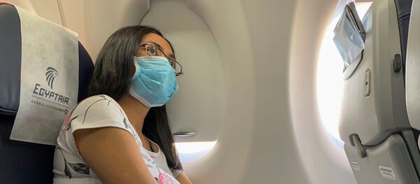 راكبة ترتدي قناعًا وقائيًا على متن رحلة تابعة لشركة مصر للطيران من الأقصر إلى القاهرة في أعقاب تفشي مرض فيروس كورونا (COVID-19) في مصر - سبوتنيك عربي