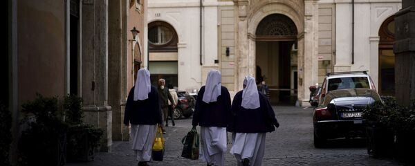 ثلاث راهبات تسرن على طول زقاق فارغ في روما بعد أن دخلت إيطاليا يومها الأول تحت حظر على الصعيد الوطني بعد مرسوم حكومي مدد القيود المفروضة على الحركة من الشمال المتضرر بشدة إلى بقية البلاد لمنع انتشار فيروس كورونا - سبوتنيك عربي