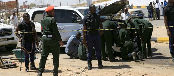 أفراد الأمن يقفون بالقرب من سيارة تضررت إثر انفجار استهدف موكب رئيس الوزراء السوداني عبد الله حمدوك بالقرب من جسر كوبر بالخرطوم - سبوتنيك عربي