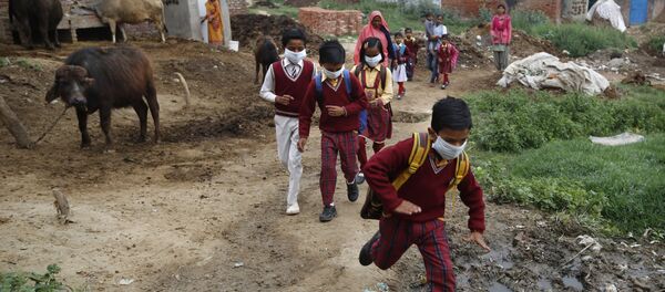 أطفال يرتدون أقنعة الوجه وسط مخاوف من انتشار فيروس كورونا ويعودون إلى منازلهم بعد أن علموا أن التجمعات العامة والمدارس مغلقة بعد أمر حكومة الولاية في وقت متأخر من الليل في قرية في كانوج في ولاية أوتار براديش الأكثر اكتظاظًا بالسكان في الهند - سبوتنيك عربي