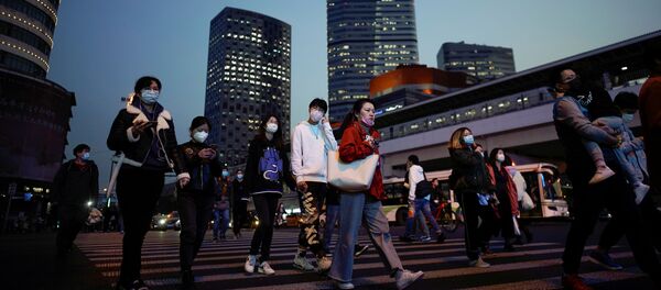 أناس يرتدون كمامات واقية من فيروس كورونا المستجد المسبب لمرض (كوفيد-19) في مدينة شنغهاي الصينية - سبوتنيك عربي