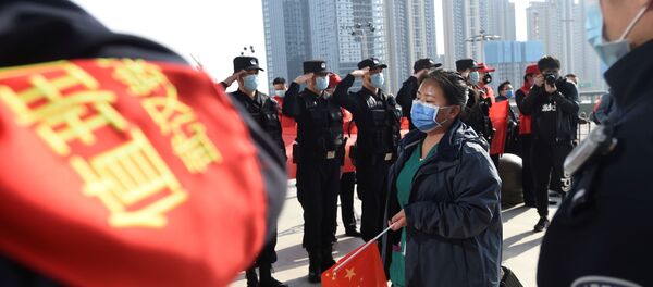 الشرطة الصينية تقدم التحية العسكرية للعاملين بالجهاز الطبي في منطقة ووهان مركز تفشي فيروس كورونا. - سبوتنيك عربي