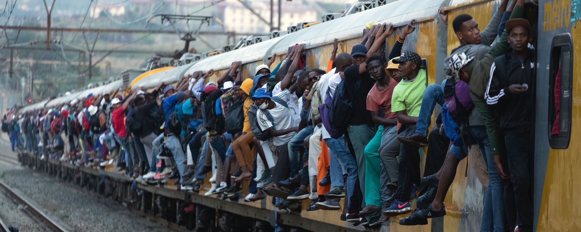 ركاب يمسكون بالقطار ركاب مكتظ في سويتو، جنوب أفريقيا، 16 مارس 2020. - سبوتنيك عربي, 1920, 21.02.2024
