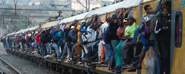ركاب يمسكون بالقطار ركاب مكتظ في سويتو، جنوب أفريقيا، 16 مارس 2020. - سبوتنيك عربي