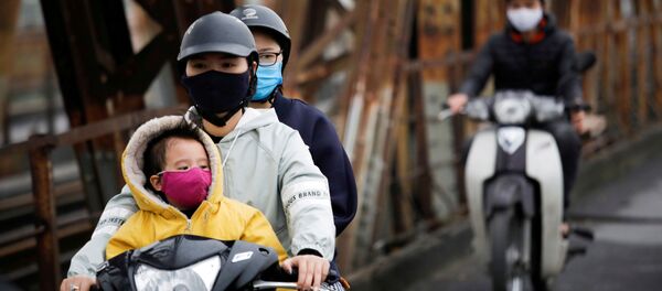 يرتدي الناس أقنعة واقية للوجه لحماية أنفسهم من فيروس كورونا التاجي في هانوي في فيتنام - سبوتنيك عربي