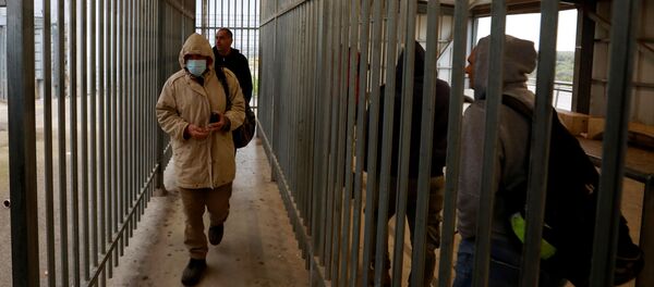 فلسطينيون عاملون في إسرائيل يتوجهون إلى العمل عبر نقطة تفتيش إسرائيلية بالقرب من رام الله في الضفة الغربية المحتلة - سبوتنيك عربي