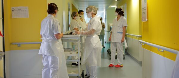 عمال طبيون يرتدون أقنعة واقية يرتدون بدلات في قسم أمراض الرئة في مستشفى فانيه في فرنسا حيث يعاني المرضى من مرض فيروس التاجي (COVID-19) - سبوتنيك عربي