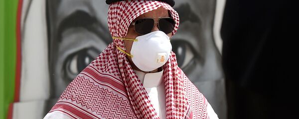 مواطن سعودي يرتدي قناعًا وقائيًا كإجراء احترازي ضد فايروس كورونا، يسير أمام لوحة جدارية تظهر وجه الملك سلمان بن عبد العزيز ، في العاصمة الرياض ، 15 مارس 2020. مواطن سعودي يرتدي قناعًا وقائيًا كإجراء احترازي ضد فايروس كورونا، يسير أمام لوحة جدارية تظهر وجه الملك سلمان بن عبد العزيز ، في العاصمة الرياض ، 15 مارس 2020. - سبوتنيك عربي