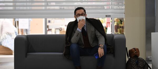 رجل يرتدي قناع الوجه الواقي يجلس على أريكة في مركز للتسوق في مدينة نوفوسيبيرسك في سيبيريا في روسيا - سبوتنيك عربي