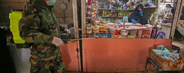 ضابط الدفاع المدني العراقي يقوم بتطهير الأماكن التجارية في ضواحي بغداد، في ظل انتشار فيروس كورونا في العراق 28  مارس 2020 - سبوتنيك عربي