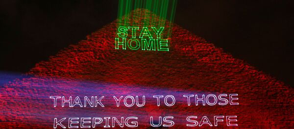 هرم خوفو أهرامات الجيزة مضاء بالنص الذي يشجع على البقاء في المنزل حيث تكثف مصر جهودها لإبطاء انتشار فيروس كورونا - سبوتنيك عربي