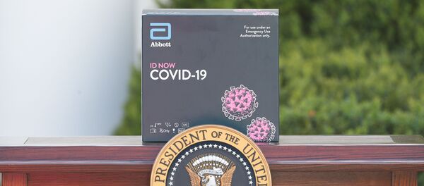 مجموعة اختبار الفيروسات التاجية خلف الشعار الرئاسي على طاولة بجانب المنصة بينما يستعد الرئيس الأمريكي دونالد ترامب للتحدث خلال الإحاطة اليومية بشأن فيروس كورونا في حديقة الورود في البيت الأبيض في واشنطن - سبوتنيك عربي