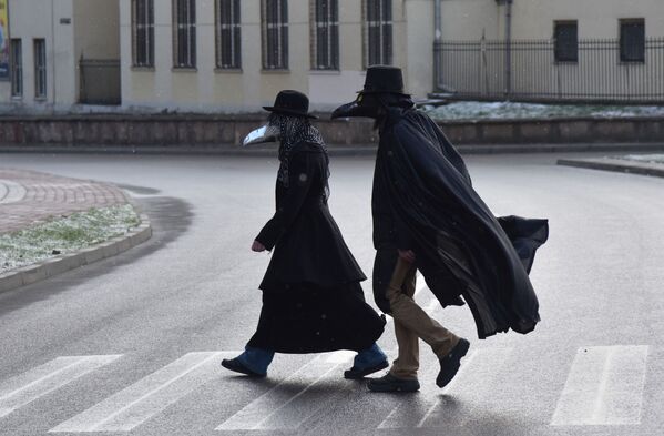 أشخاص يرتدون أقنعة طبيب الطاعون في لفيف وسط تفشي مرض فيروس التاجي كورونا، أوكرانيا 22 مارس 2020 - سبوتنيك عربي