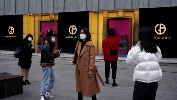 أشخاص يرتدون أقنعة الوجه خارج متجر جورجيو أرماني في أحد مراكز التسوق في ووهان بمقاطعة هوبي مركز تفشي مرض فيروس  كورونا في الصين - سبوتنيك عربي