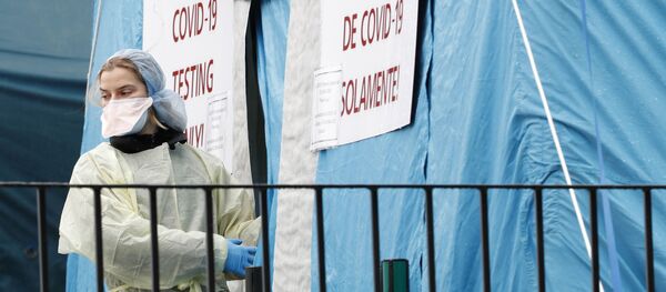 عاملة طبية تستعد لدخول خيمة اختبار COVID-19 التي أقيمت خارج مركز مستشفى إلمهورست في نيويورك - سبوتنيك عربي