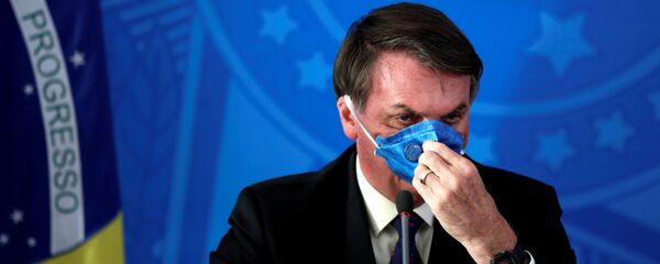 الرئيس البرازيلي جايير بولسونارو يعدل قناع وجهه أثناء بيان صحفي حول تفشي مرض فيروس كورونا (COVID-19) في البرازيل ، 20 مارس 2020 - سبوتنيك عربي