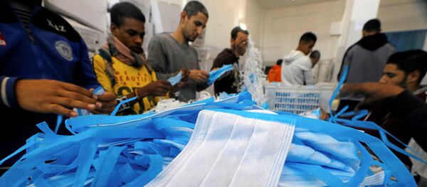 عمال في مصنع ينتج معدات جراحية معقمة وملابس طبية في حين تكثف مصر جهودها لإبطاء انتشار فيروس كورونا - سبوتنيك عربي