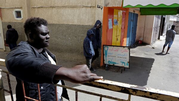 مهاجرون أفارقة يقفون في منطقة حي الفرح خلال إغلاق لاحتواء انتشار مرض فيروس كورونا على مشارف الرباط في المغرب  - سبوتنيك عربي