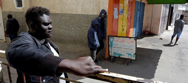 مهاجرون أفارقة يقفون في منطقة حي الفرح خلال إغلاق لاحتواء انتشار مرض فيروس كورونا على مشارف الرباط في المغرب  - سبوتنيك عربي