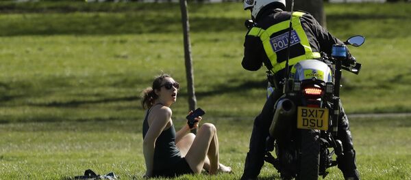 شرطي يطلب من فتاة مغادرة الحديقة، في ظل الإجراءات التقييدية خلال وباء الفيروس التاجي كورونا في لندن، بريطانيا 5 أبريل 2020 - سبوتنيك عربي