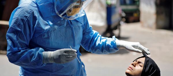 طبيب يرتدي بدلة واقية يفحص فتاة، تحاليل فيروس كورونا، في أحمد آباد، الهند 8 أبريل 2020 - سبوتنيك عربي