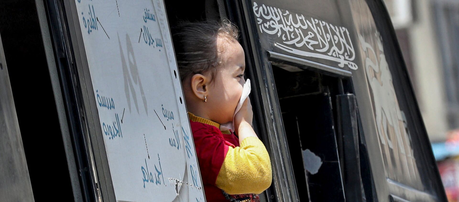 فتاة تحمي فمها وسط مخاوف من فيروس كورونا وتطل من نافذة حافلة في القاهرة - سبوتنيك عربي, 1920, 28.06.2021