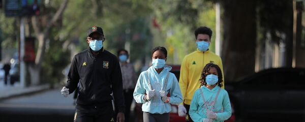 عائلة تمشي أثناء ارتدائها أقنعة الوجه في حي الزمالك الراقي حيث تكثف مصر جهودها لإبطاء انتشار مرض التاجية (COVID-19) في القاهرة - سبوتنيك عربي