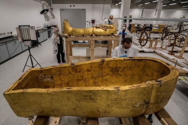  علماء آثار مصريون يرتدون الكمامات الحماية  من عدوى كورونا، خلال ترميم التابوت الذهبي للفرعون توت عنخ آمون (الذي حكم بين 1342 إلى 1325 ق.م.) في معمل الترميم بالمتحف المصري الكبير، الذي شيد حديثا في الجيزة بضواحي  القاهرة ، 13 أبريل 2020. - سبوتنيك عربي