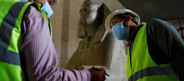  موظفون يرتدون كمامات طبية لتفادي الإصابة بفيروس كورونا  في المتحف المصري الكبير، الذي شيد حديثا في الجيزة بضواحي  القاهرة ، 13 أبريل 2020. - سبوتنيك عربي
