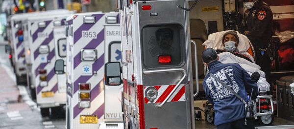 مريض يصل بسيارة إسعاف برعاية عاملين طبيين يرتدون معدات وقائية بسبب مخاوف كوفيد-19  خارج مركز جامعة نيويورك لانغون الطبي، 13 أبريل 2020 ، في نيويورك، الولايات المتحدة - سبوتنيك عربي