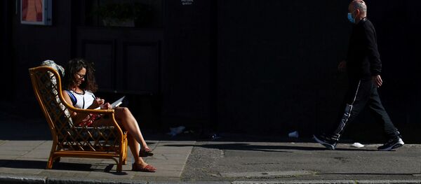 امرأة تجلس في الخارج في  حي داتسون، على خلفية انتشار مرض فيروس كورونا (كوفيد-19)، لندن، بريطانيا، 14 أبريل 2020. - سبوتنيك عربي