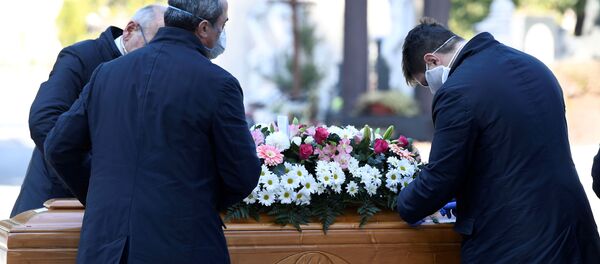 عمال المقبرة وموظفو خدمة الجنازات ينقلون تابوت شخص توفي بسبب فيروس كورونا في بيرغامو، إيطاليا - سبوتنيك عربي