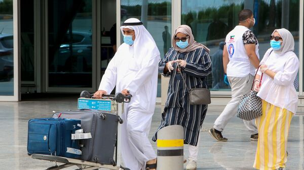 يغادر المواطنون الكويتيون المقيمون في الخارج مطار الكويت الدولي في العاصمة عند عودتهم كجزء من خطة الإعادة إلى الوطن في 19 أبريل 2020 ، وقبل نقلهم إلى الحجر الصحي الإلزامي - سبوتنيك عربي