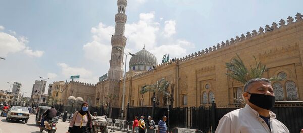 رجل يرتدي كمامة واقية من فيروس كورونا يسير أمام مسجد السيدة زينب المغلق - سبوتنيك عربي