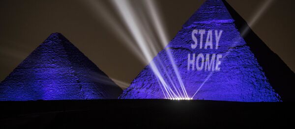 إضاءة أهرامات الجيزة عبارة ابق في البيت في القاهرة، في إطار حملة توعوية لمنع انتشار فيروس كورونا في مصر، 18 أبريل 2020 - سبوتنيك عربي