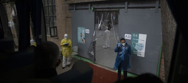 عامل يقف بالقرب من محطة معالجة للركاب الذين يصلون من ووهان في بكين  - سبوتنيك عربي