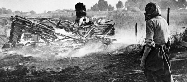 صور من أرشيف الحرب الوطنية العظمى (1941 - 1945) - امرأة تقف وسط حقل أحرقه النازيون في إحدى قرى بيلاروسيا قبل الانسحاب منها، 1944 - سبوتنيك عربي