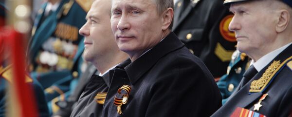 أفضل صور العرض العكسري بمناسبة عيد النصر على مدار السنين في روسيا - الرئيس فلاديمير بوتين يجلس مع المحاربين القدامى الأبطال أثناء مشاهدة العرض العسكري على الساحة الحمراء في الذكرى الـ66  لعيد النصر في الحرب الوطنية العظمى ضد ألمانيا النازية (1941-1945) - سبوتنيك عربي