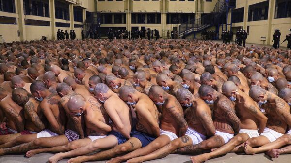 في هذه الصورة التي نشرها المكتب الصحفي لرئاسة السلفادور، يظهر فيها السجناء خلال عملية أمنية تحت مراقبة الشرطة في سجن إيزالكو في سان سلفادور في 25 أبريل 2020. حيث قامت السلطات بحشر السجناء معا، وإن كانوا يرتدون الكمامات، في ساحات السجن أثناء تفتيش الزنازين. وكان قد أمر الرئيس ناييب بوكيلي بالحملة بعد مقتل أكثر من 20 شخصًا في البلاد، وأشارت المخابرات المحلية إلى أن الأوامر (بالقتل) جاءت من قادة العصابات المسجونين. - سبوتنيك عربي