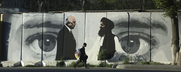 صبي صغير يحمل كيسًا من البضائع على ظهره يمشي خلف جدار في كابول في أفغانستان يصور مبعوث واشنطن للسلام زلماي خليل زاد والملا عبد الغني بارادار رئيس وفد طالبان صبي صغير يحمل كيسًا من البضائع على ظهره يمشي خلف جدار في كابول في أفغانستان يصور مبعوث واشنطن للسلام زلماي خليل زاد والملا عبد الغني بارادار رئيس وفد طالبان - سبوتنيك عربي