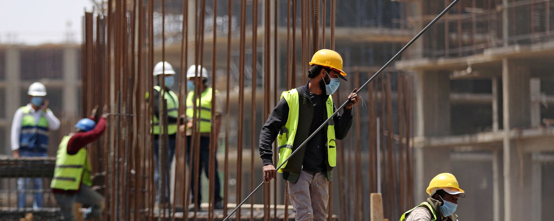 عمال يرتدون أقنعة واقية يقفون على مبنى قيد الإنشاء في العاصمة الإدارية الجديدة شرق القاهرة - سبوتنيك عربي, 1920, 14.11.2021